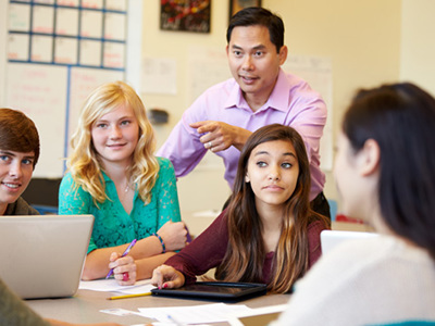  High School Students With Teacher In Class Using Laptops 