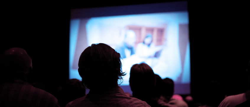 Silhouette of person watching a film