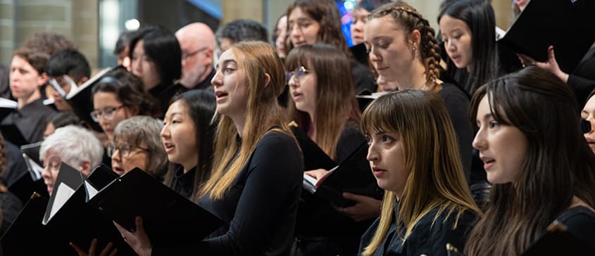 Womens chorus singers performing.