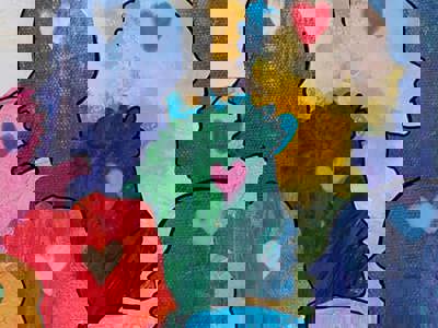 Multi-coloured friendly faces in profile with hearts in their minds.