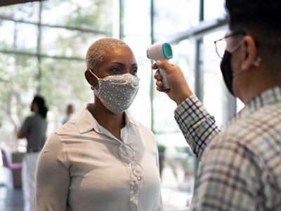 Photo of a woman being temperature scanned