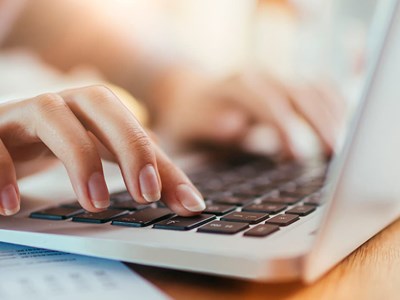 Picture of hands typing on a laptop.