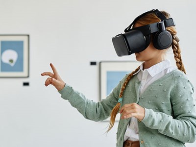 Image of a girl in a museum with virtual reality goggles.