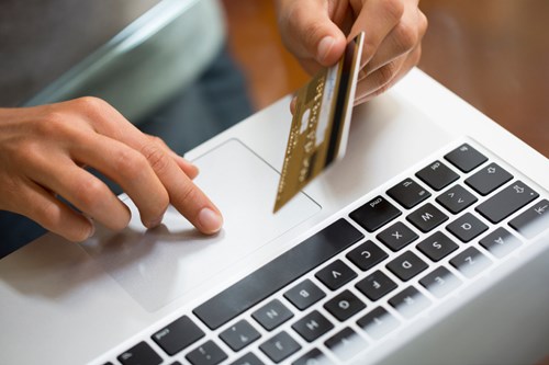 Photograph of student using a credit card to pay for a course online